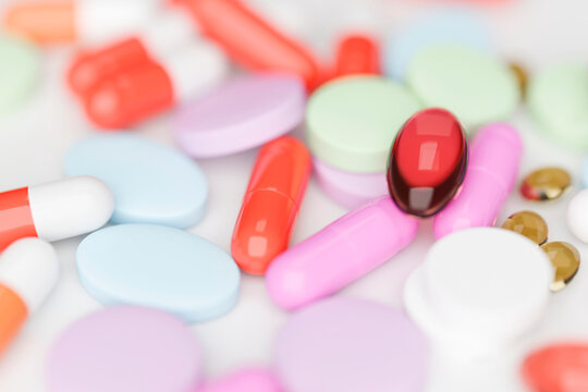 Close-up of colorful pills and capsules on white surface
