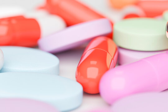 Close-up of colorful pills and capsules on white surface