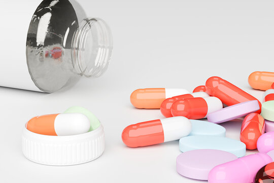 Scattered pills and capsules beside open medicine bottle
