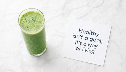 Fototapeta premium Fresh green smoothie in a glass with an inspirational quote on a white marble background