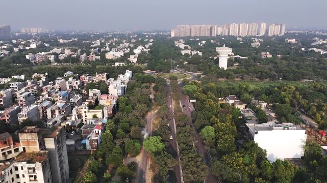 Aerial view of Greater Noida with residential buildings, lush green trees, and a water tower in Greater Noida, Uttar Pradesh, India.