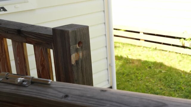 Hand unlocking slide bolt latch on a wooden garden gate outdoors