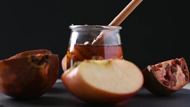 Rotating honey jar, pomegranates and apples for Rosh Hashanah celebration