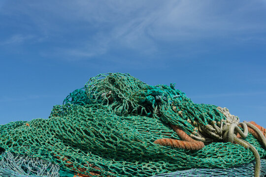 Fishing nets and ropes piled high under blue sky