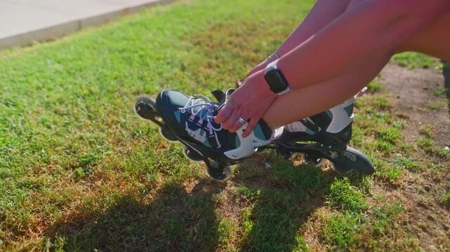 A person prepares to rollerblade by adjusting their skates on a lush green lawn, showcasing the excitement of outdoor activity and fitness.