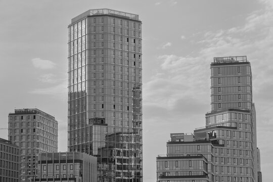 Modern skyscrapers with glass facade cladding under cloudy sky. Contemporary architecture corporate buildings in metropolis financial district.