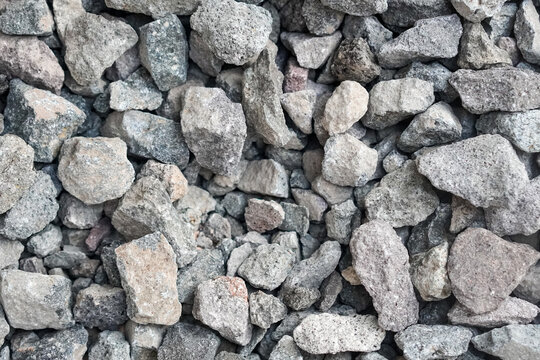 Gray gravel background with natural crushed stones and rough texture, photographed from above to create a versatile abstract surface for construction, design, and outdoor themes.