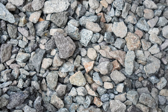 Gray gravel background with natural crushed stones and rough texture, photographed from above to create a versatile abstract surface for construction, design, and outdoor themes.