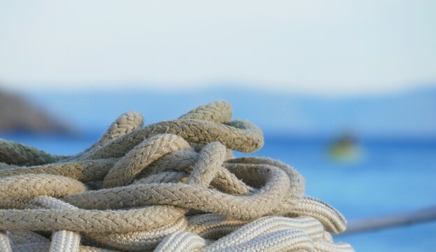 Rope for the boat by the blue sea in the Mediterranean city, nautical equipment background