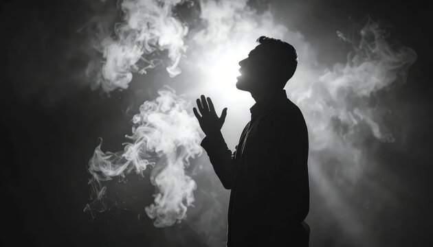 Silhouette of Praying Figure in Dramatic Backlit Smoke.