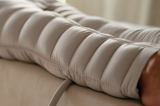 An intimate shot of a leg compression sleeve, emphasizing its padded texture and therapeutic purpose to provide comfort and enhance recovery during relaxation.