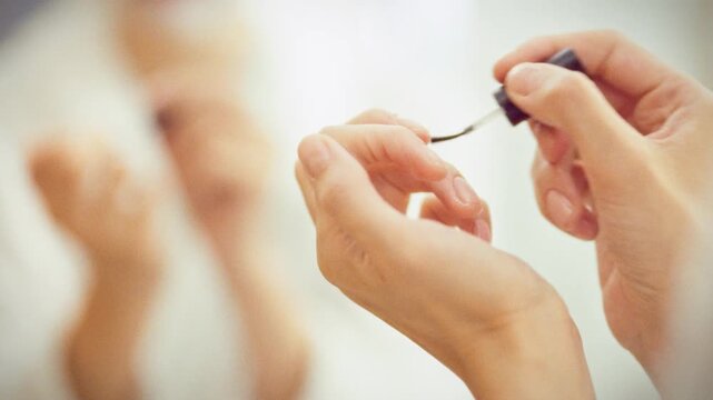 Close-up shows a girl gently applying nourishing oil to her cuticles and surrounding skin with an applicator brush, a careful daily nail-care step that keeps nails healthy and hydrated