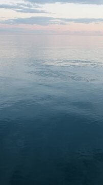 Calm sea horizon at sunset vertical video peaceful ocean water pastel sunset sky background tranquil marine landscape minimal nature backdrop copy space calm atmosphere