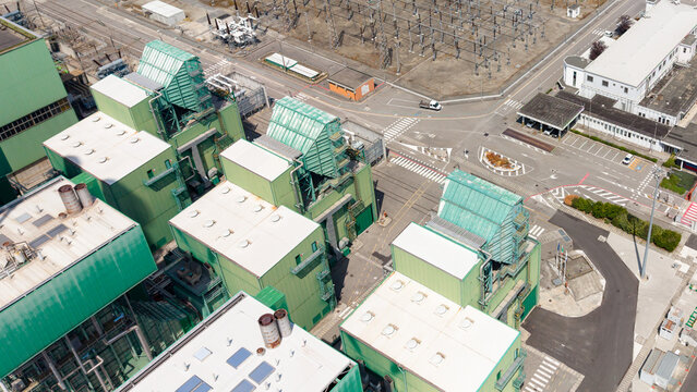 Aerial view of the Tavazzano Montanaso thermal power plant featuring green industrial buildings, gas turbine equipment, and electrical substation in Tavazzano con Villavesco, Lombardy, Italy.