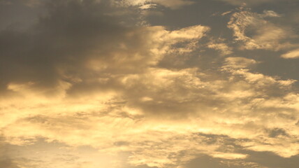 Fototapeta premium Golden Hour Bright Sunlight Illuminating Textured Golden Clouds In A Dramatic Sky