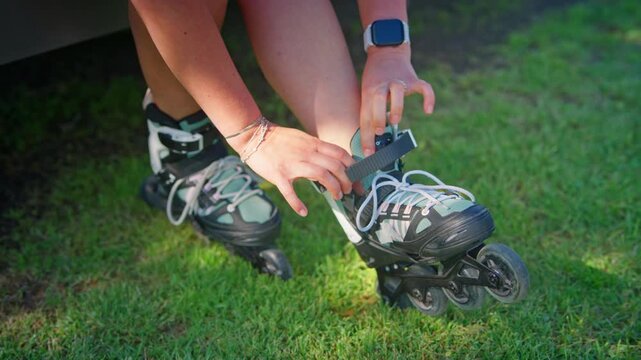 A Focused Moment: Preparing for an Exciting Outdoor Rollerblading Adventure with Strapping on Inline Skates in the Sunlit Grass