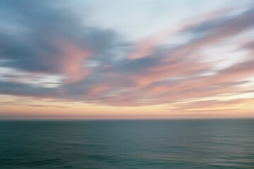 Obraz premium The Ocean Horizon at Sunset with Soft Blurred Clouds and Calm Waters
