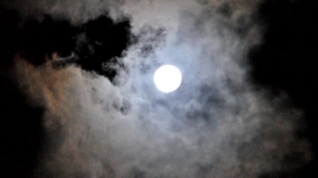Midnight sky with full moon and slowly floating clouds in the mysterious night sky, night sinister landscape with Halloween atmosphere