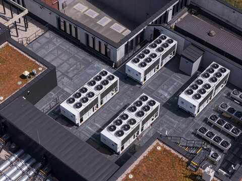 Aerial view of industrial HVAC cooling units installed on a modern building rooftop in Poland.