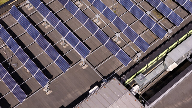 Aerial view of solar panels installed on a flat industrial roof in Poland.
