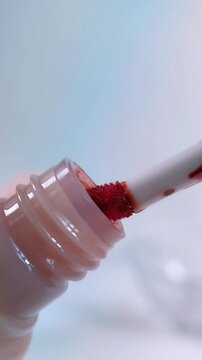 Process of opening pink product packaging cap. Lip tint product with mini red brush inside. Vertical video for beauty product advertisement concept.