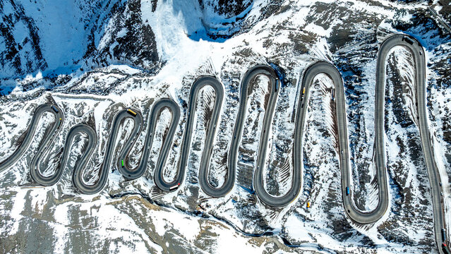 Aerial view of the winding Caracoles de Portillo mountain road featuring sharp switchbacks and heavy snow cover in the Andes, Portillo, Valparaiso, Chile.