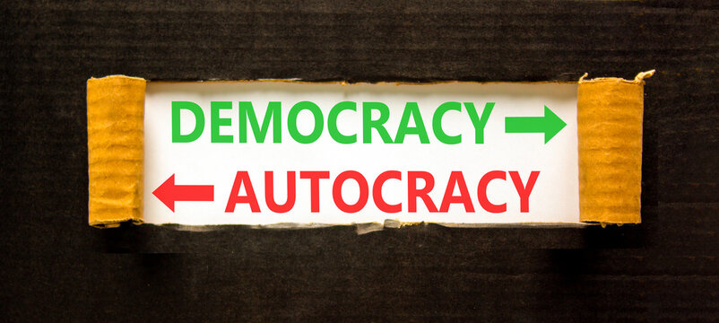 Democracy or autocracy words symbol. Concept words Democracy Autocracy on beautiful white paper. Beautiful black background. Business democracy autocracy concept. Copy space