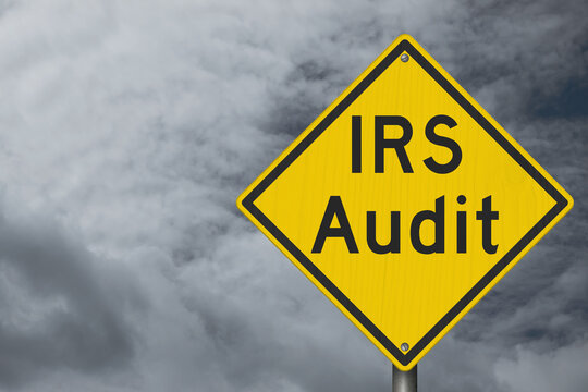 IRS Audit yellow warning sign with stormy sky tax review
