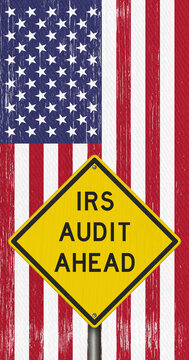 IRS Audit Ahead yellow warning sign on the American flag tax review