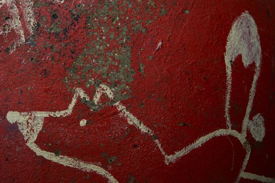 Weathered red wall with cream graffiti drips in Berlin