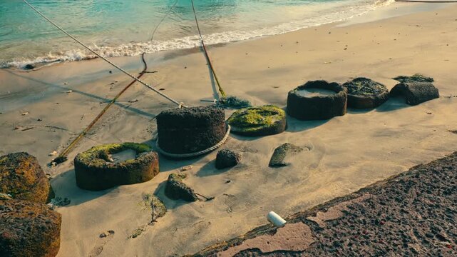 Concrete Mooring Blocks and Ropes on Sandy Beach