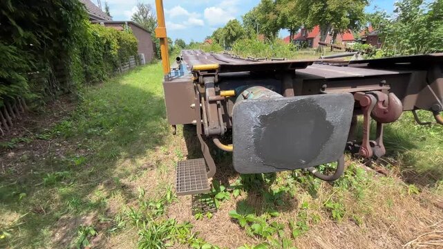 Detailed close-up of the coupling system, buffers and technical hardware on a freight railway wagon in Germany. Industrial railway equipment and cargo transport infrastructure in daylight.