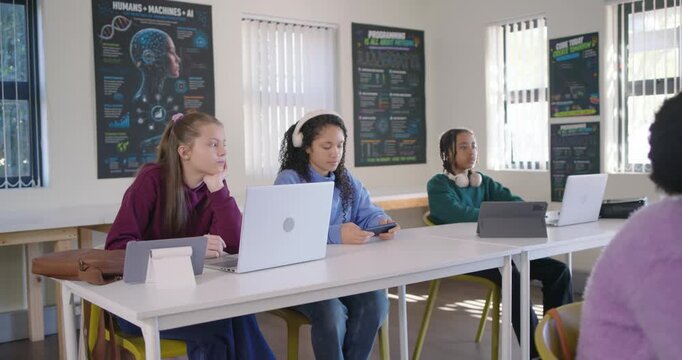 Teen female students shifting, listening toward right after boy gesturing, checking phone, laptop
