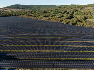 Solar farm with many photovoltaic panels generates clean electricity in rural setting under clear sky. This promotes renewable energy use. © 24K-Production