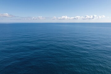 Fototapeta premium The Ocean Horizon: A Vast Blue Seascape Over Calm Sea and Sky