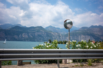 Obraz premium View of a lake with mountains and a mirror along the roadside on a cloudy day