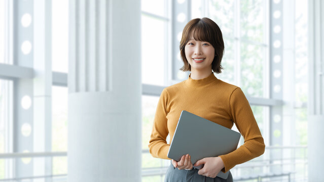 ノートパソコンを持つ女性・ビジネスウーマン, Businesswoman Holding a Laptop Computer