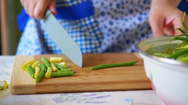 Close-Up of Hands Chopping Fresh Green and Yellow Beans on Wooden Board