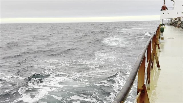 cargo ship proceeding at sea with favoring wind and waves.