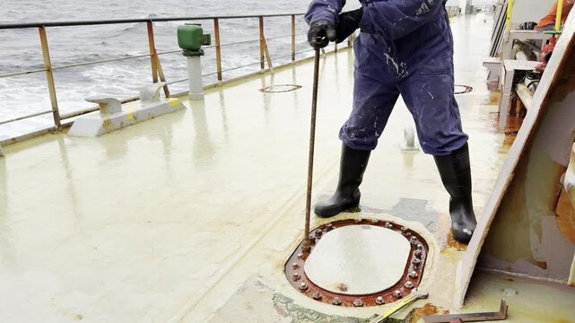 seafarer remove nuts from ballast tank. ship at sea.