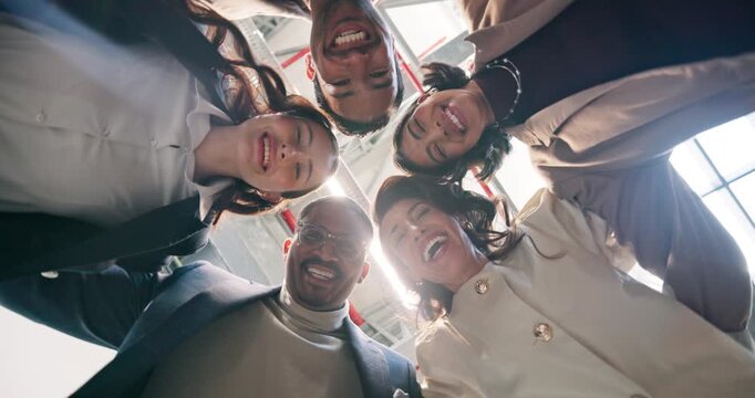 Team, face and huddle with business people in office for support, laugh and solidarity with low angle. Partnership, collaboration and mission with employee in agency for community and diversity