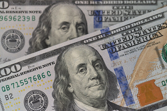 Detailed macro shot of 100 US dollar banknotes with selective focus on the portrait of Benjamin Franklin. Perfect for financial, business, investment, economy, trade, and banking concepts.