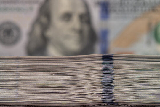 Side view macro stack of hundred US dollar bills with blurred background