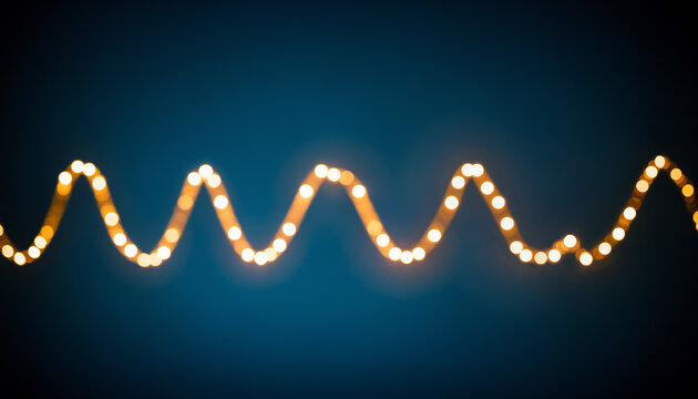 a string of glowing warm yellow lights arranged in a wavy line against a dark blue background