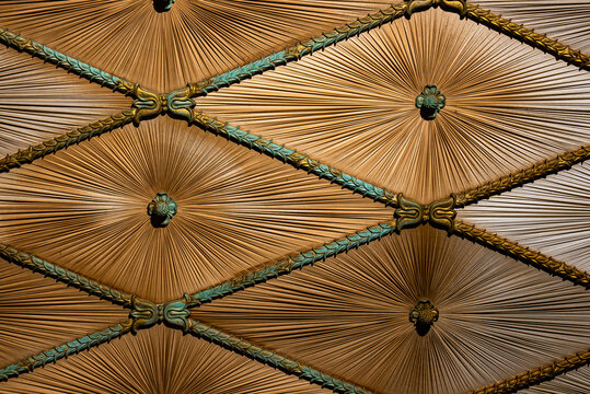 Intricate ceiling design with a geometric pattern and brass decorative elements. Concept of luxury architecture, interior design, and historical craftsmanship for commercial use.