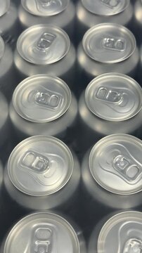 Rows of sealed aluminum cans are grouped in multipacks, creating a clean commercial display suitable for wholesale supply, retail sales and beverage distribution. Close up.