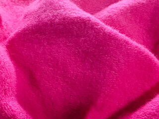 Folded hot pink soft fleece fabric texture background with shadow and depth © Jasid Gallery