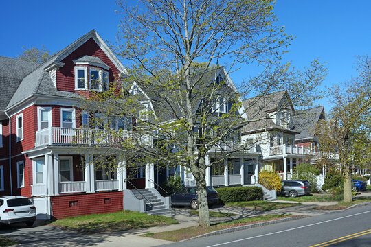 suburban street of three story clapboard houses with large verandas
