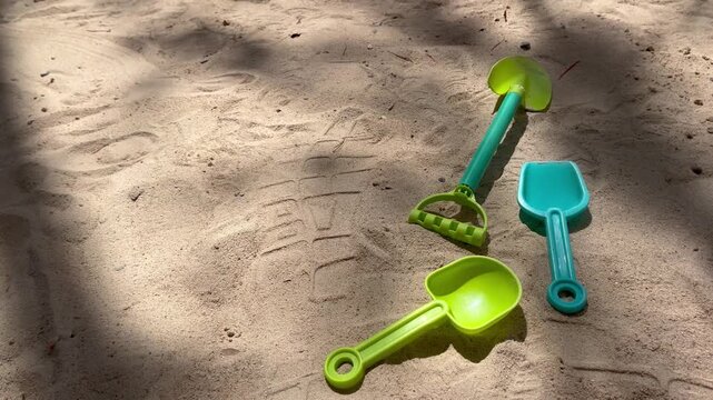 Plastic toys shovels and spades on a sandy beach