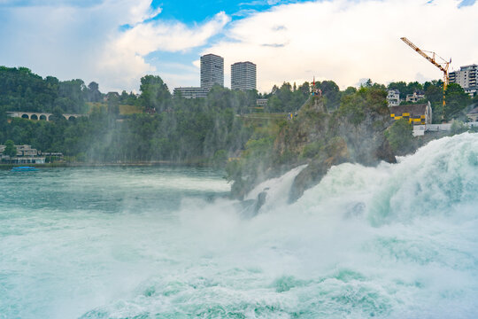 Rhine Falls Waterfall with Rapid Cascading Water and City Skyline in Neuhausen Switzerland. Powerful Water fall Stream Rheinfall.